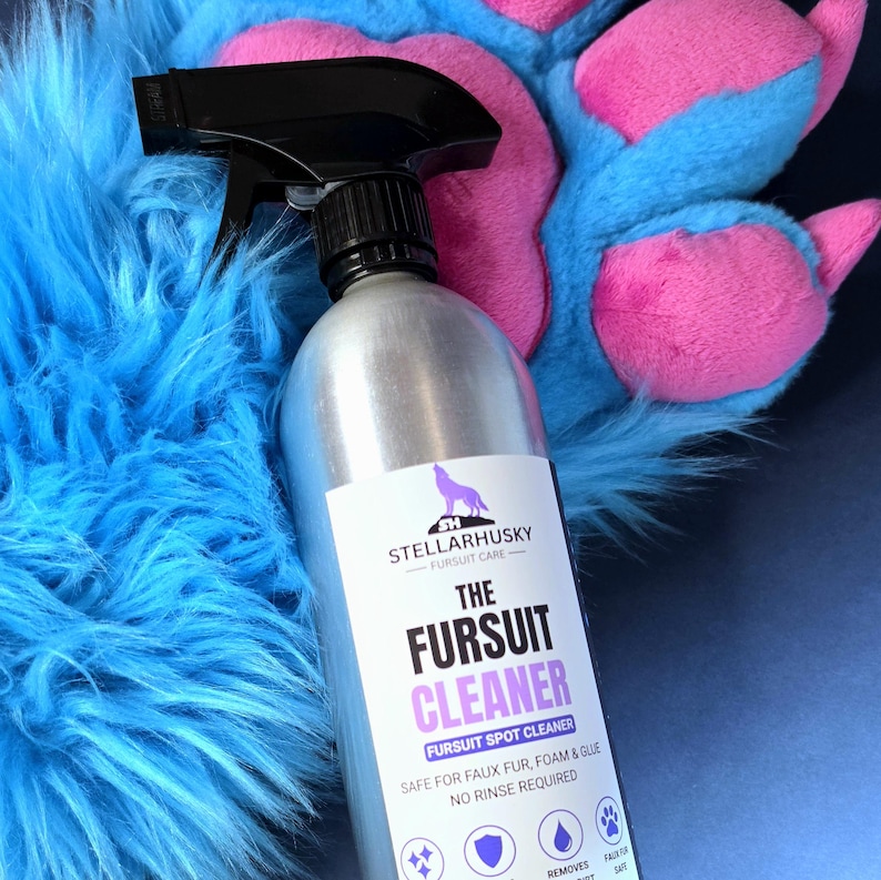 May include: A silver spray bottle with a black trigger nozzle featuring a white label that reads STELLARHUSKY FURSUIT CARE THE FURSUIT CLEANER FURSUIT SPOT CLEANER SAFE FOR FAUX FUR, FOAM & GLUE NO RINSE REQUIRED, positioned against blue faux fur.