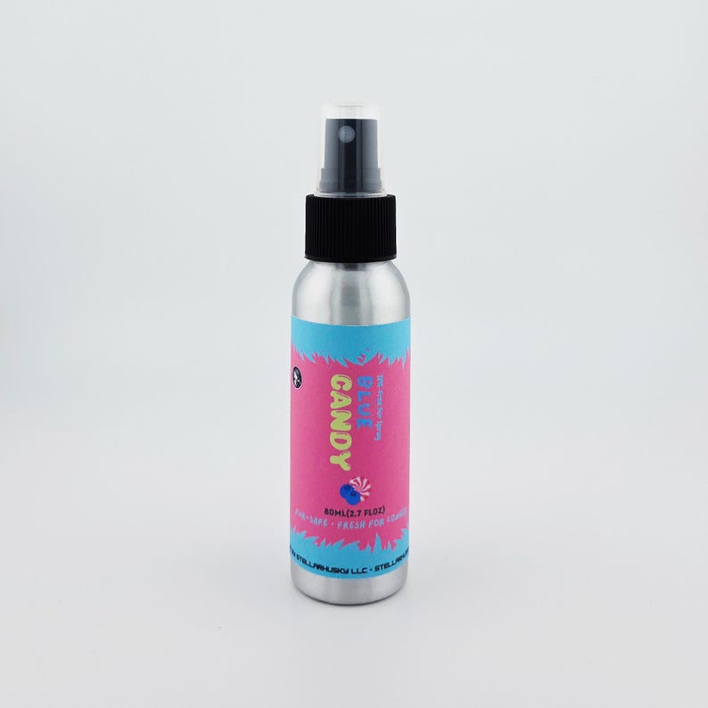 May include: A silver spray bottle with a black cap and a pink and blue label. The label reads "CANDY Blue Razz" with a graphic of a blue candy. The bottle contains 50ml (1.7 fl oz) of product.