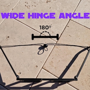 May include: Black metal hinge with a wide angle design, shown open. The text "WIDE HINGE ANGLE" is displayed in purple, with "180&deg;" indicating the angle of the hinge.