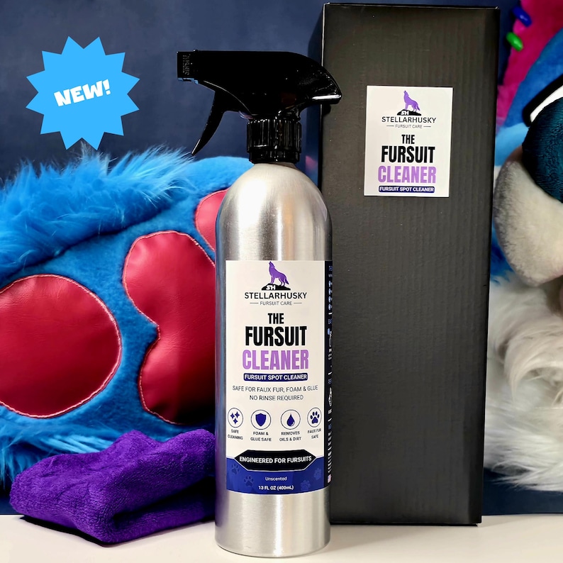 May include: A silver spray bottle of StellarHusky Fursuit Cleaner with a black trigger nozzle. The label features a wolf logo, the text The Fursuit Cleaner, and states 13 fl oz (400ml). A blue starburst with the text NEW is visible.