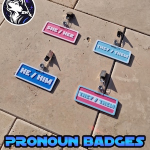 Pronoun badges on display on a tile background, badges displaying she/her, they/them, he/him and a they/them in the trans colours.
