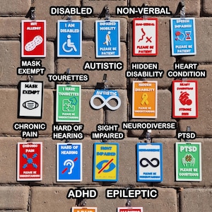 May include: A collection of colorful, rectangular medical alert tags with various symbols and text, including "Nut Allergy," "Disabled," and "Autistic." Each tag has a different design and message, such as "Please Be Patient."