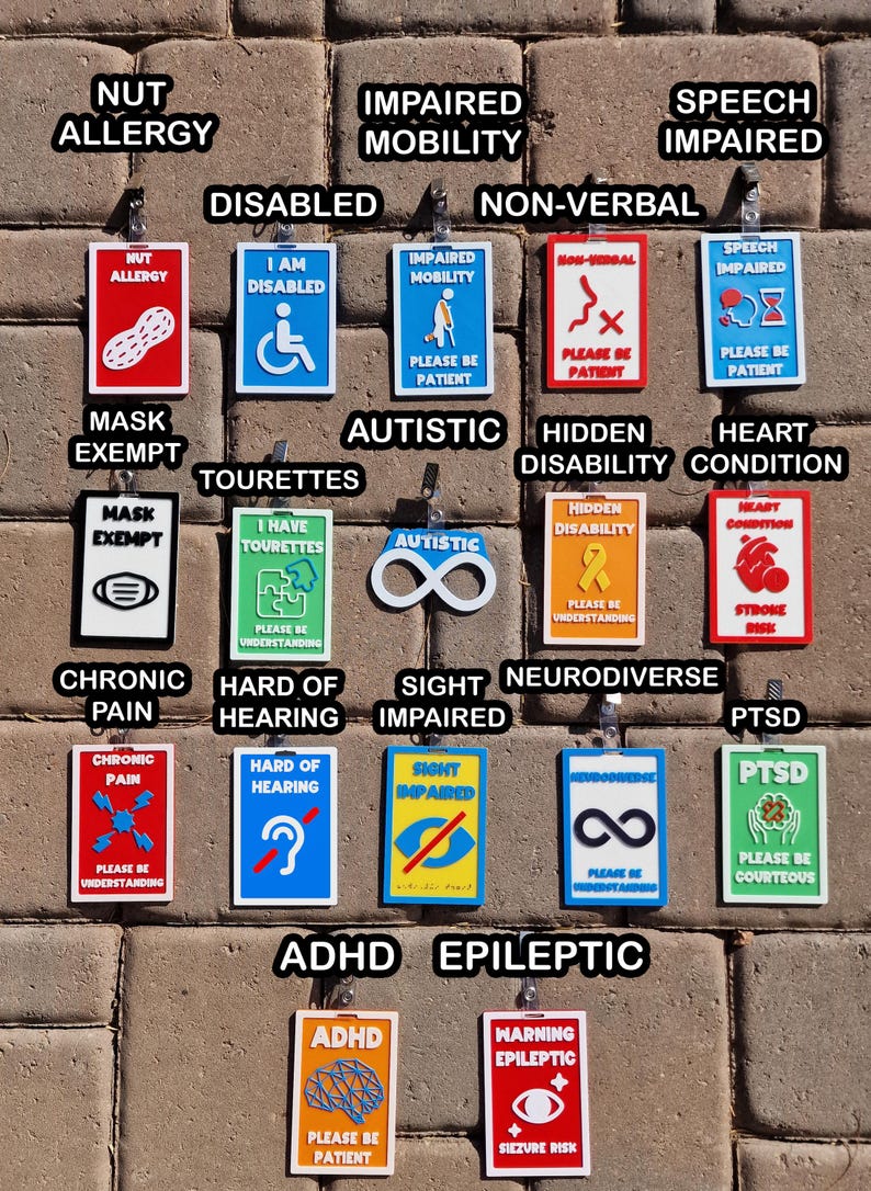 May include: A collection of colorful, rectangular medical alert tags with various symbols and text, including "Nut Allergy," "Disabled," and "Autistic." Each tag has a different design and message, such as "Please Be Patient."