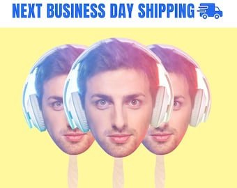 May include: Three face fans with a man's face wearing headphones. The fans are on wooden sticks, with a yellow background. The text at the top says "ORDER BEFORE 5PM EST FOR NEXT BUSINESS DAY SHIPPING".