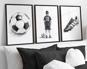 May include: Three black framed prints with white backgrounds. The left print shows a black and white drawing of a soccer ball. The center print shows a black and white drawing of a boy wearing a soccer jersey with the number 10 and the name Lucas. The right print shows a black and white drawing of a soccer cleat.