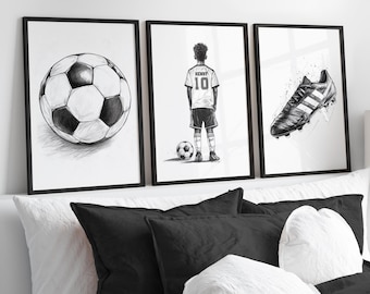 Peut inclure: Trois impressions encadrées noires avec des fonds blancs. L'impression de gauche montre un dessin en noir et blanc d'un ballon de football. L'impression du milieu montre un dessin en noir et blanc d'un joueur de football portant un maillot avec le numéro 10 et le nom "Henry" au dos. L'impression de droite montre un dessin en noir et blanc d'une chaussure de football.