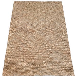 May include: A natural fibre rug with a woven texture in shades of brown and beige.