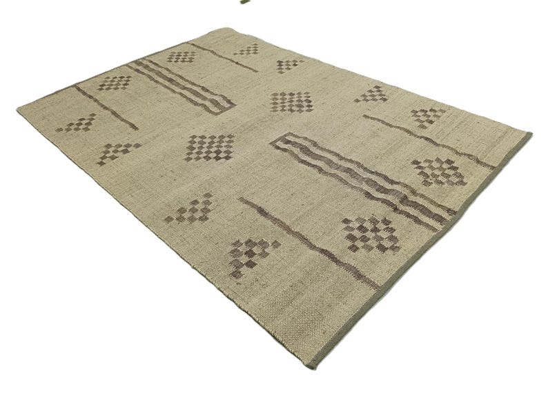 May include: A beige rug with a geometric pattern in brown. The pattern features squares and diamonds.