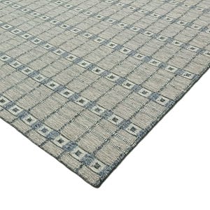 Peut inclure: Gros plan sur un tapis gris et bleu à motifs géométriques. Le tapis a un léger brillant et une texture douce.