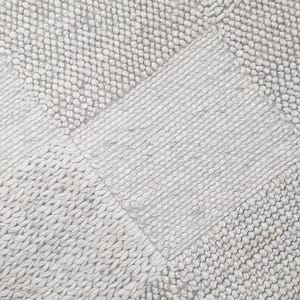 Peut inclure: Gros plan sur un tapis tissé gris clair avec une surface texturée. Le tapis est fait de petites boucles rondes de fil.