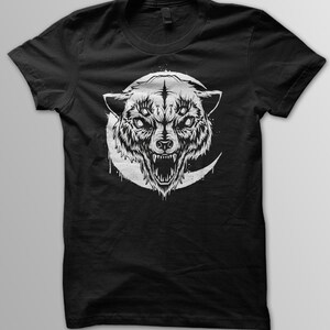 May include: Black t-shirt with a white graphic of a wolf's head with three eyes and a crescent moon behind it.
