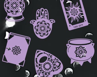 May include: A set of six purple-colored, decorative, mystical, and spiritual themed items. The items include a crystal ball, a hamsa hand, a tarot card with the sun symbol, a book, a cauldron, and a pentagram.