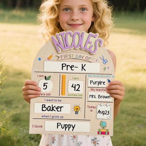 May include: A wooden first day of school sign with a light wood finish, featuring the name NICOLE'S in purple, with fillable sections for grade Pre-K, age 5, height 42 inches, favorite color purple, teacher Mrs. Brown, career Baker, and interest Puppy.