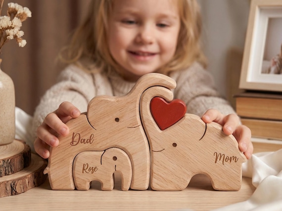 A family of wooden elephants cut as an interlocking puzzle where each piece is a parent or child — personalized names turn it into an instant keepsake that earns a spot on the shelf, not the drawer.