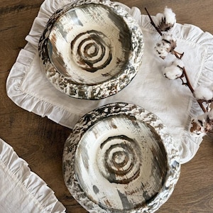 May include: Two white ceramic bowls with a brown and gray swirl design. The bowls have a rustic, distressed look and are perfect for serving snacks or salads.
