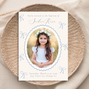 May include: A baptism invitation with a photo of a young girl wearing a white dress and a flower crown. The invitation is decorated with blue bows and the text "You're invited to the baptism of Sadie Rose. Saturday, March 15 at 11am 6331 Forest Ln. Orange Ca"
