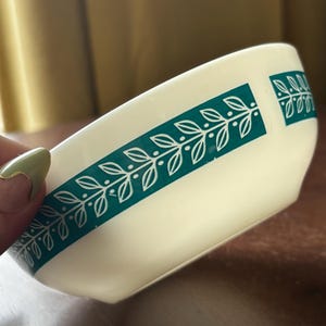 May include: White ceramic bowl with a green and white leaf design around the rim.