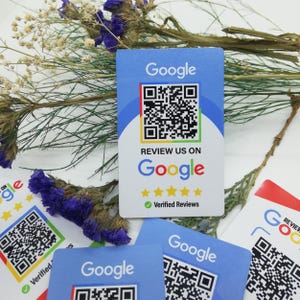 Puede incluir: Varias tarjetas azules con el logotipo de Google y códigos QR. Las tarjetas también muestran el texto "Revisanos en Google" y "Reseñas verificadas" con valoraciones de estrellas. El fondo incluye flores secas.