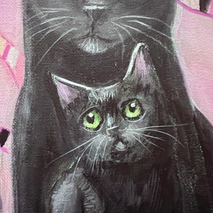 May include: A close-up painting of two black cats. The larger cat has yellow eyes, and the smaller cat has green eyes. The background is a soft pink with hints of purple and white.