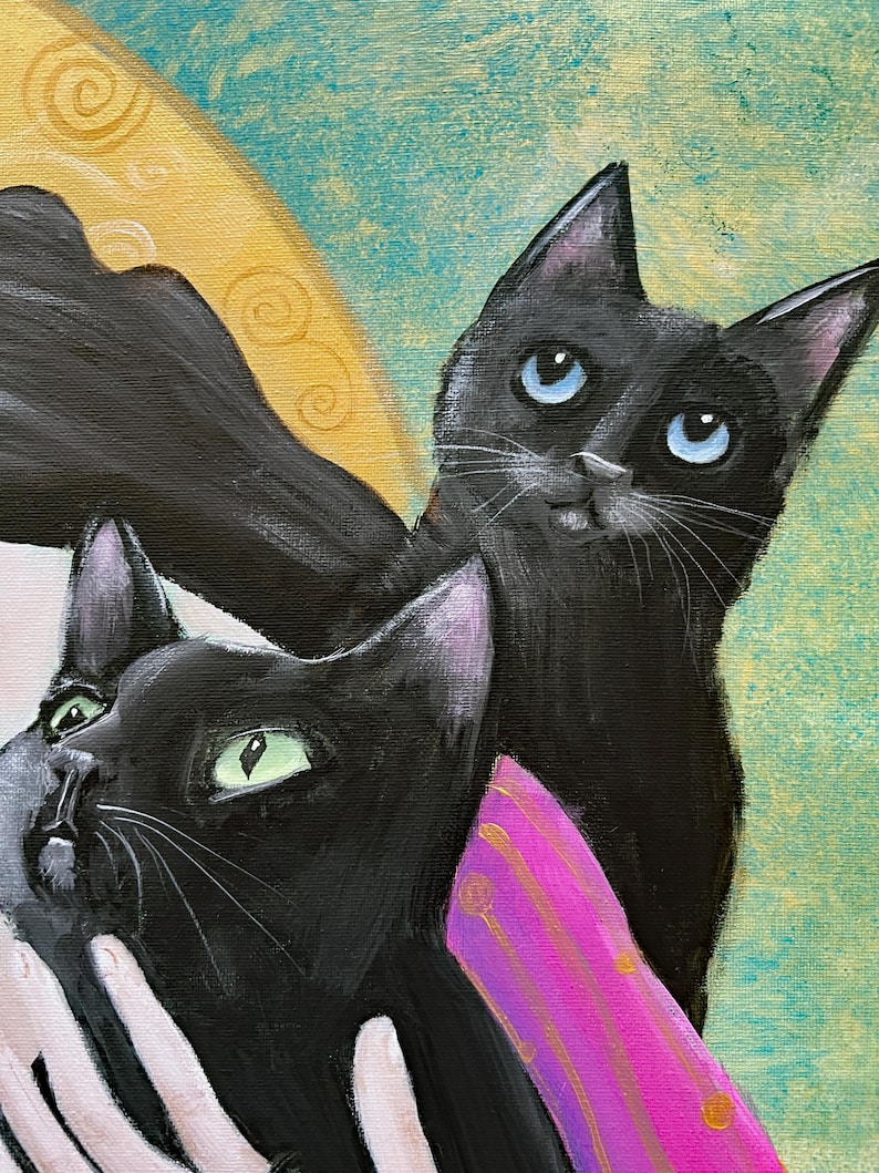 May include: An artistic painting featuring two black cats with expressive eyes. One cat has blue eyes, the other green. The background is a mix of teal and gold, with a pink and gold accent.