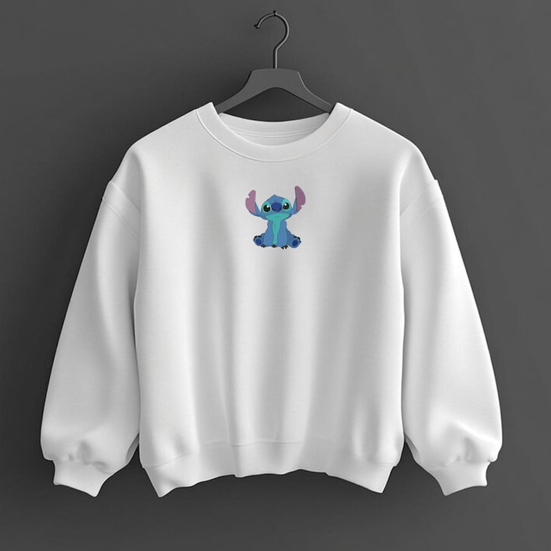 May include: White crew neck sweatshirt with a small embroidered Stitch character. The Stitch design is blue with pink ears. The sweatshirt has long sleeves and a relaxed fit. A casual, comfortable garment.