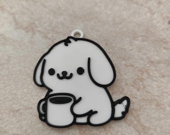 May include: A white cartoon dog charm with black outlines, holding a coffee mug. The charm has a small loop at the top for hanging. The dog has a smiling face and is sitting down.