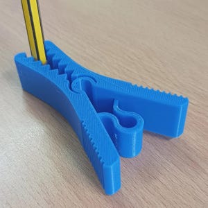 Peut inclure: Un porte-crayons en plastique bleu avec une surface texturée. Le porte-crayons est conçu pour maintenir les crayons à la verticale.