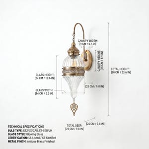 May include: A wall sconce with an antique brass finish and a clear ribbed glass shade. Dimensions include a 23.6 inch total height, 10.6 inch glass height, 5.5 inch glass width, 3.5 inch canopy width, 5.9 inch canopy height, and 9.8 inch depth.