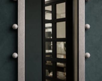 May include: A rectangular wall mirror with a metallic silver frame. The frame is decorated with twelve spherical accents featuring a white and grey marbled pattern, positioned at regular intervals along the outer edges of the mirror frame.