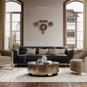 May include: A living room with a dark grey sofa, beige cushions, and a round coffee table. A wall clock with Arabic script and a family name is mounted above the sofa. The sofa is 255 cm wide, and the clock is 30 cm.