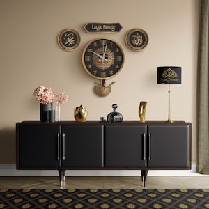 May include: A black and gold wall clock with a decorative pendulum hangs above a black cabinet. The clock is surrounded by gold-framed wall art and a lamp. The cabinet has gold handles and legs. The rug has a gold pattern.