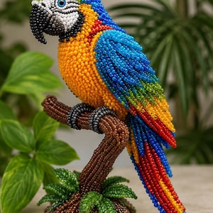 Könnte beinhalten: Eine handgefertigte Perlenfigur eines Ara-Papageis, der auf einem braunen Ast sitzt. Der Vogel besteht aus leuchtend blauen, gelben, grünen und roten Perlen, mit einem schwarzen Schnabel und weißen Gesichtsdetails. Der Sockel ist texturiert.