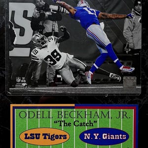 May include: A black and white image of a football play with two players. One player in a blue and white uniform is reaching for the ball. The other player is on the ground. The image includes text that reads "ODELL BECKHAM, JR. "The Catch" LSU Tigers N.Y. Giants".