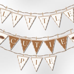 May include: A banner with triangular flags spelling out "LITTLE CUTIE PIE". The flags alternate between brown and white, with a brown and white striped pattern. The banner is strung on a brown string with small wooden clothespins.