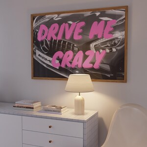 May include: A framed print featuring a black and white photograph of a car with the words "DRIVE ME CRAZY" in pink lettering.