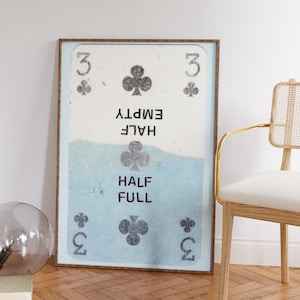 Może przedstawiać: Wydruk w ramie karty do gry z trójką trefl. Karta jest podzielona na pół, z górną połową z napisem "HALF EMPTY" i dolną połową z napisem "HALF FULL".
