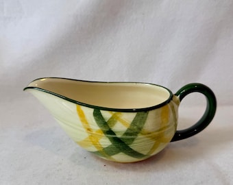Una salsera o jarra para crema de cerámica Vernon Ware de estilo vintage con el estampado "Gingham" que presenta un diseño a cuadros verdes y amarillos.