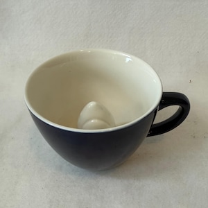 May include: A set of three ceramic mugs with a speckled, matte finish. Each mug features a different color: light blue, cream, and gray. The mugs have a simple, modern design with a rounded shape and a comfortable handle.