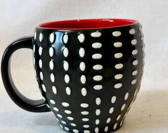 Una taza de café Starbucks descatalogada del año 2008. Está hecha de porcelana fina y presenta un diseño texturizado distintivo con lunares blancos en relieve.