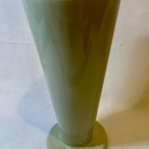 Puede incluir: Una taza de cer&aacute;mica blanca con un asa negra y el texto "But First, Coffee" en un estilo manuscrito. La taza est&aacute; sobre una superficie blanca. La taza mide aproximadamente 10 cm de alto.