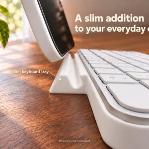 May include: A white slim keyboard tray with a built-in slot for holding a smartphone upright. The tray features the text A slim addition to your everyday carry and the label Slim keyboard tray. The device is white with a smooth finish.
