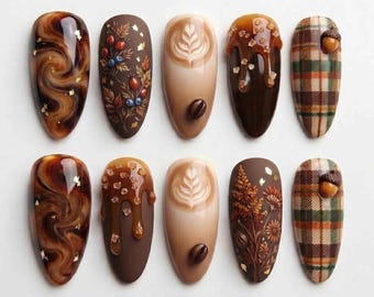 May include: Ten almond-shaped press-on nails featuring autumn-themed designs including brown marble swirls with gold flakes, botanical illustrations with berries, latte art with coffee beans, caramel drip with sugar crystals, and brown plaid with acorns.