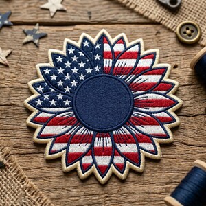 May include: Embroidered patch in the shape of a sunflower, featuring the American flag design. The patch has a blue center and petals with red and white stripes and white stars. The patch is on a wooden surface.