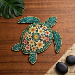 May include: An embroidered sea turtle patch featuring a teal and green body with a detailed shell pattern. The shell is decorated with multiple white, yellow, and pink plumeria flowers and a central sunburst design, all outlined in gold thread.