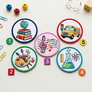May include: Five circular embroidered patches featuring school-themed designs: a globe on books, a yellow school bus, a music staff with notes, an artist palette with brushes, and a science flask with an atom. Numbered squares 1-5 are included.