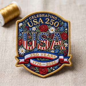 May include: Embroidered patch celebrating USA's 250th anniversary. The patch features the text "CELEBRATING USA 250" and "USA" in red and white stripes with blue stars. Floral accents include red roses, white daisies, and blue flowers. A banner reads "250 YEARS 1776-2026".