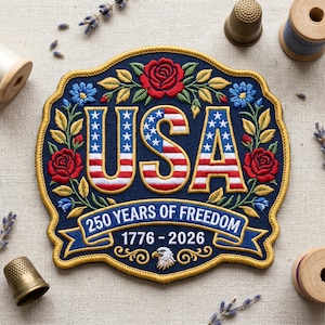 May include: Embroidered patch with a navy blue background, featuring the word "USA" in red and white stripes with blue stars. The patch is decorated with red roses, blue flowers, and gold trim. Text reads "250 YEARS OF FREEDOM 1776-2026".