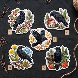 May include: Five embroidered patches featuring black crows in various poses. Patch 1 shows a crow on a branch with red berries. Patch 2 features a crow with mushrooms. Patch 3 depicts a crow in flight. Patch 4 shows a crow with dandelions. Patch 5 displays a crow with pinecones.