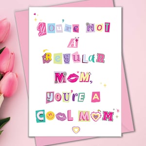 May include: A greeting card with the text "You're Not A Regular Mom, You're A Cool Mom" in a colorful, cut-out style. The card is on a pink background with a bouquet of pink and white tulips.