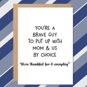 May include: A white greeting card with the text "YOU'RE A BRAVE GUY TO PUT UP WITH MOM & US BY CHOICE" in black font. The card also includes the phrase "We're thankful for it everyday" with a small red heart. The card is in a brown envelope.